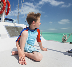 Boy on a boat in a swimsuit on the ocean